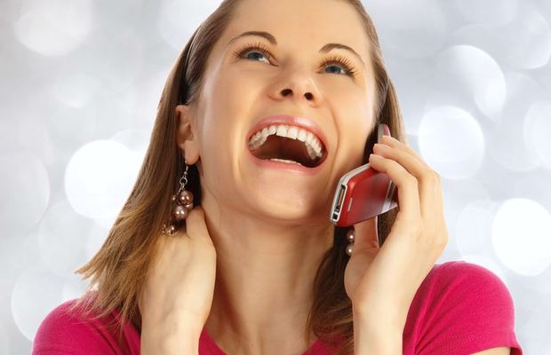 A young woman laughs as she talks on her mobile phone