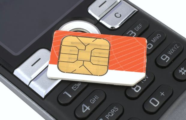 Close-up of a phone keypad with a SIM card resting on the keys