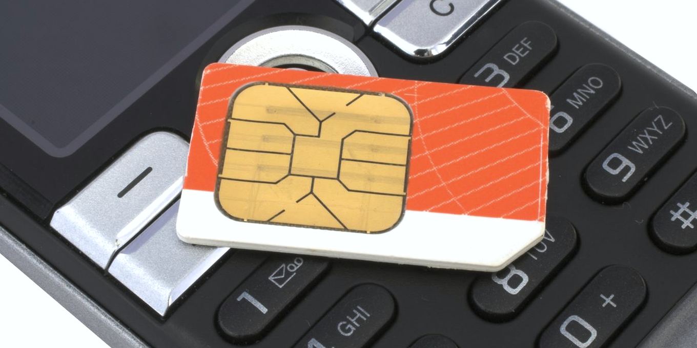 Close-up of a phone keypad with a SIM card resting on the keys